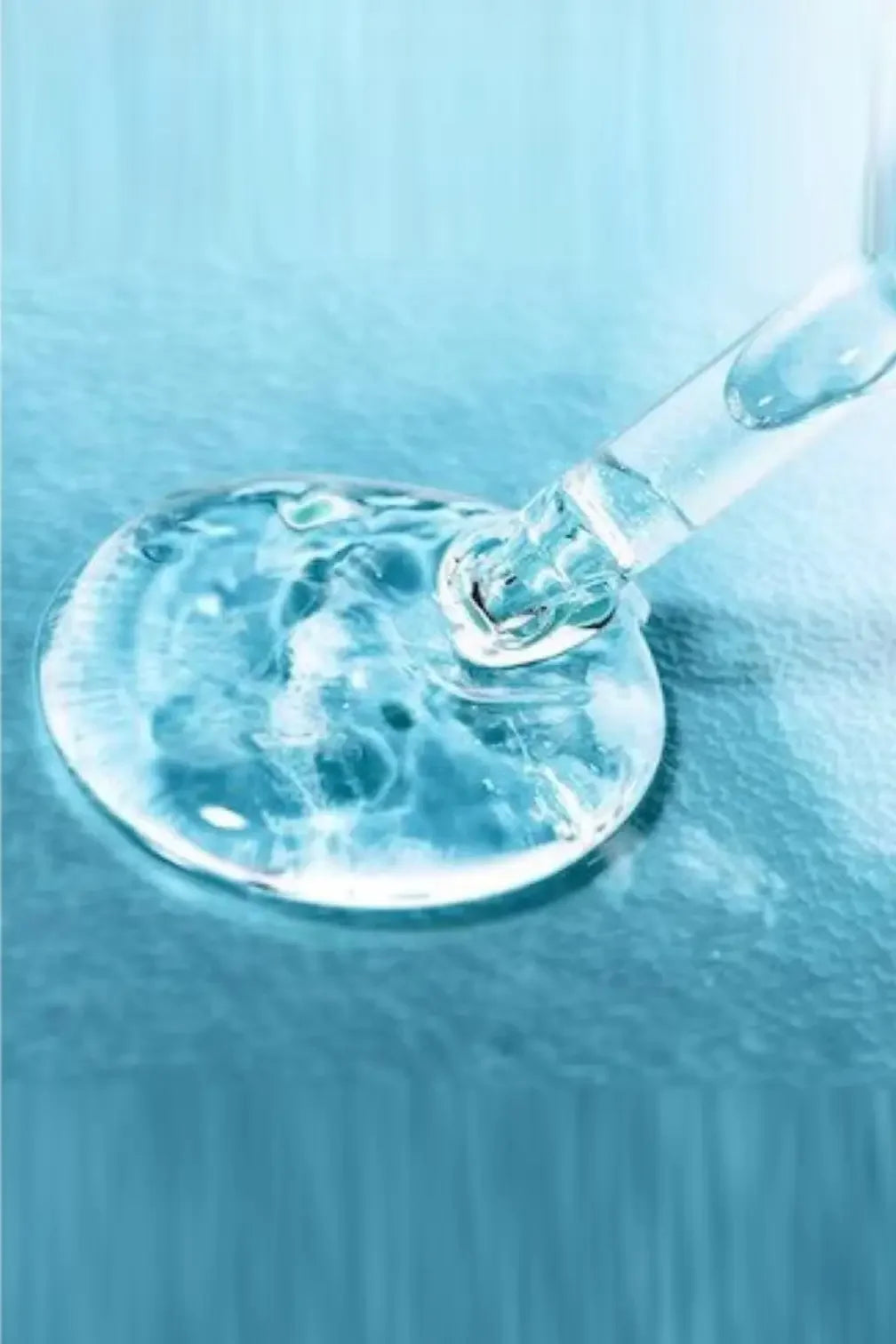 Clear serum dropper with niacinamide toner on blue surface, skincare product close-up